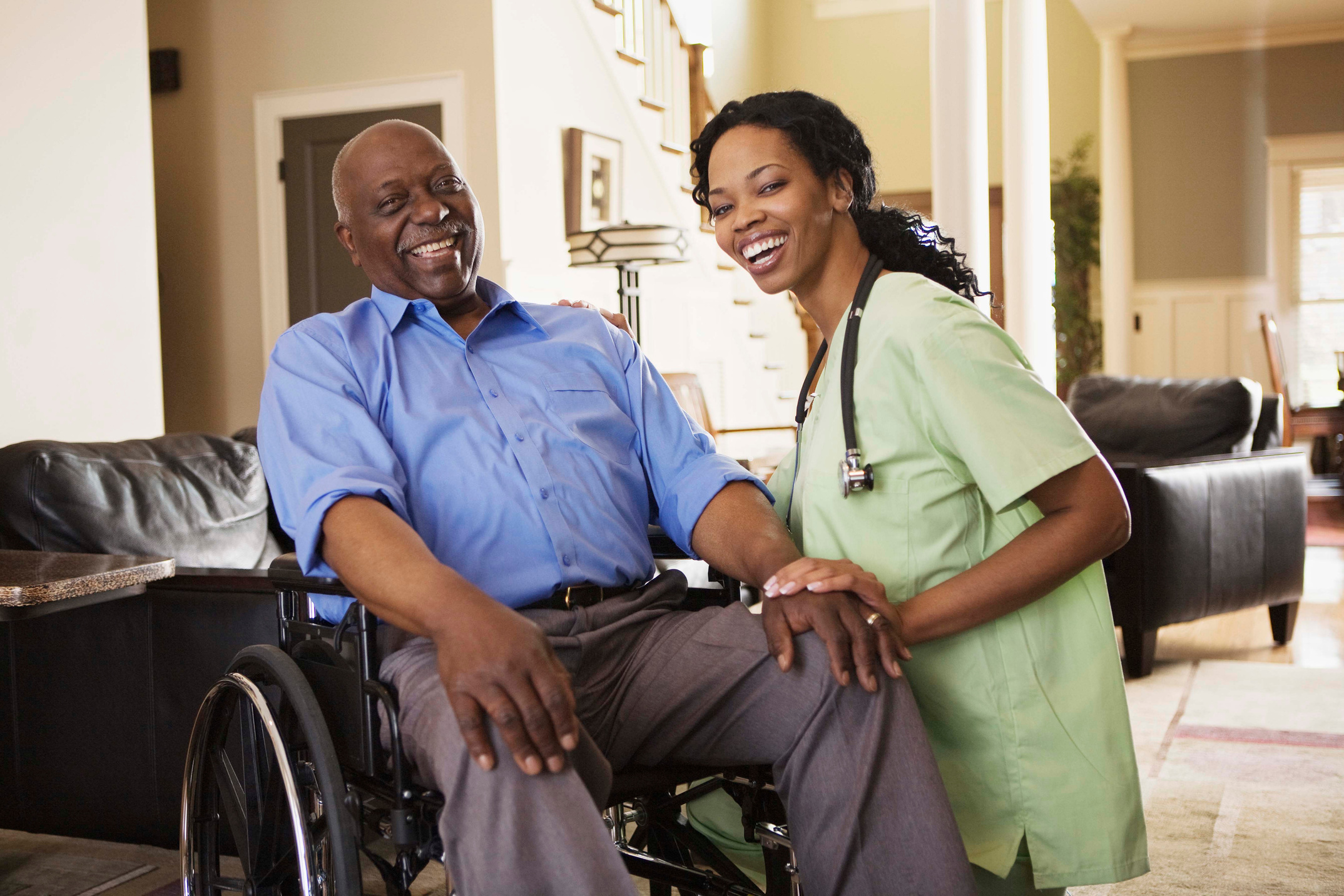 Nurse with man in wheelchair at home